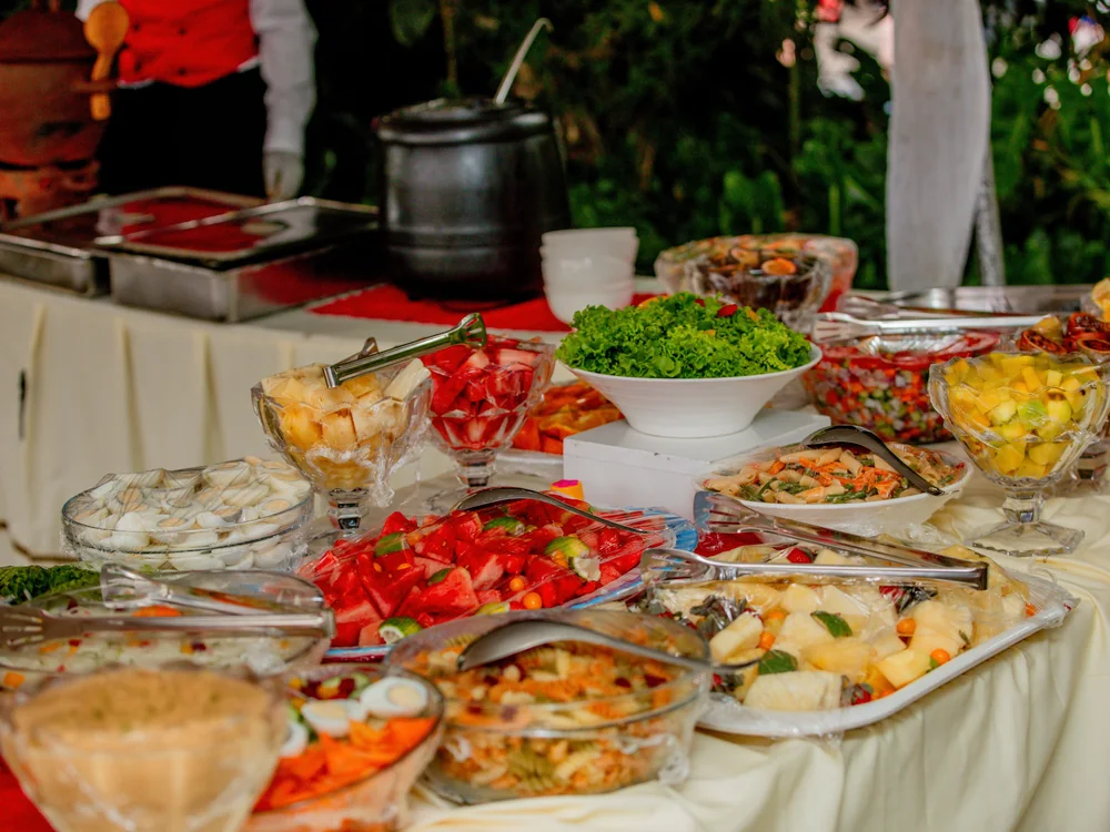 A buffet table spread with fresh fruit, salads and island dishes